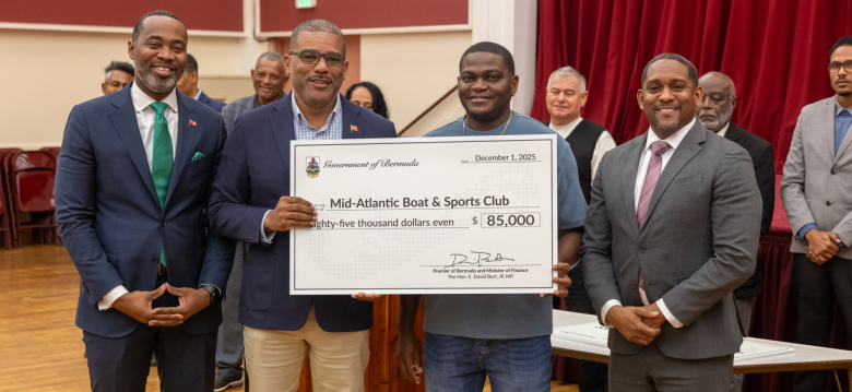 4 men in photo presenting check